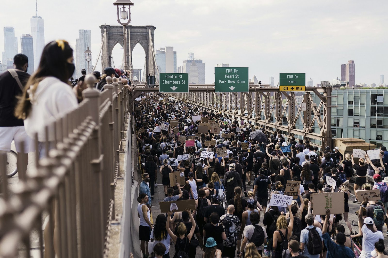 Crowds of protestors marching across the Brooklyn Bridge towards Manhattan Island