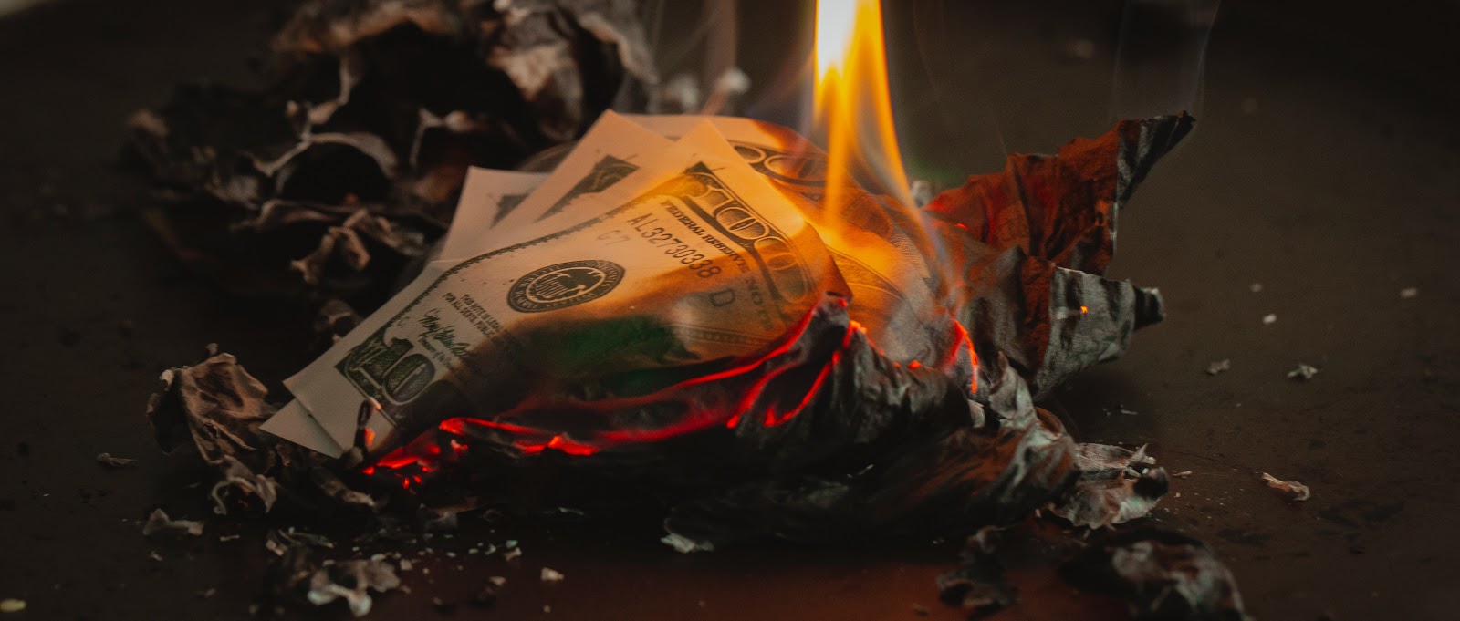 100 US dollar bills burning intoashes