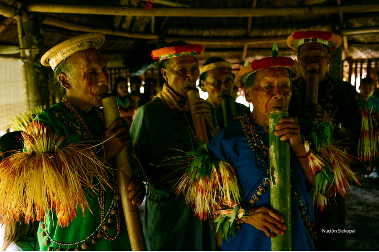 Indigenous elders playing pipes