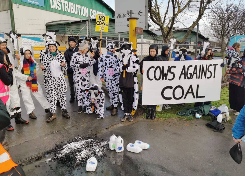 Fotografia da ação, com banner "Vacas contra ocarvão"