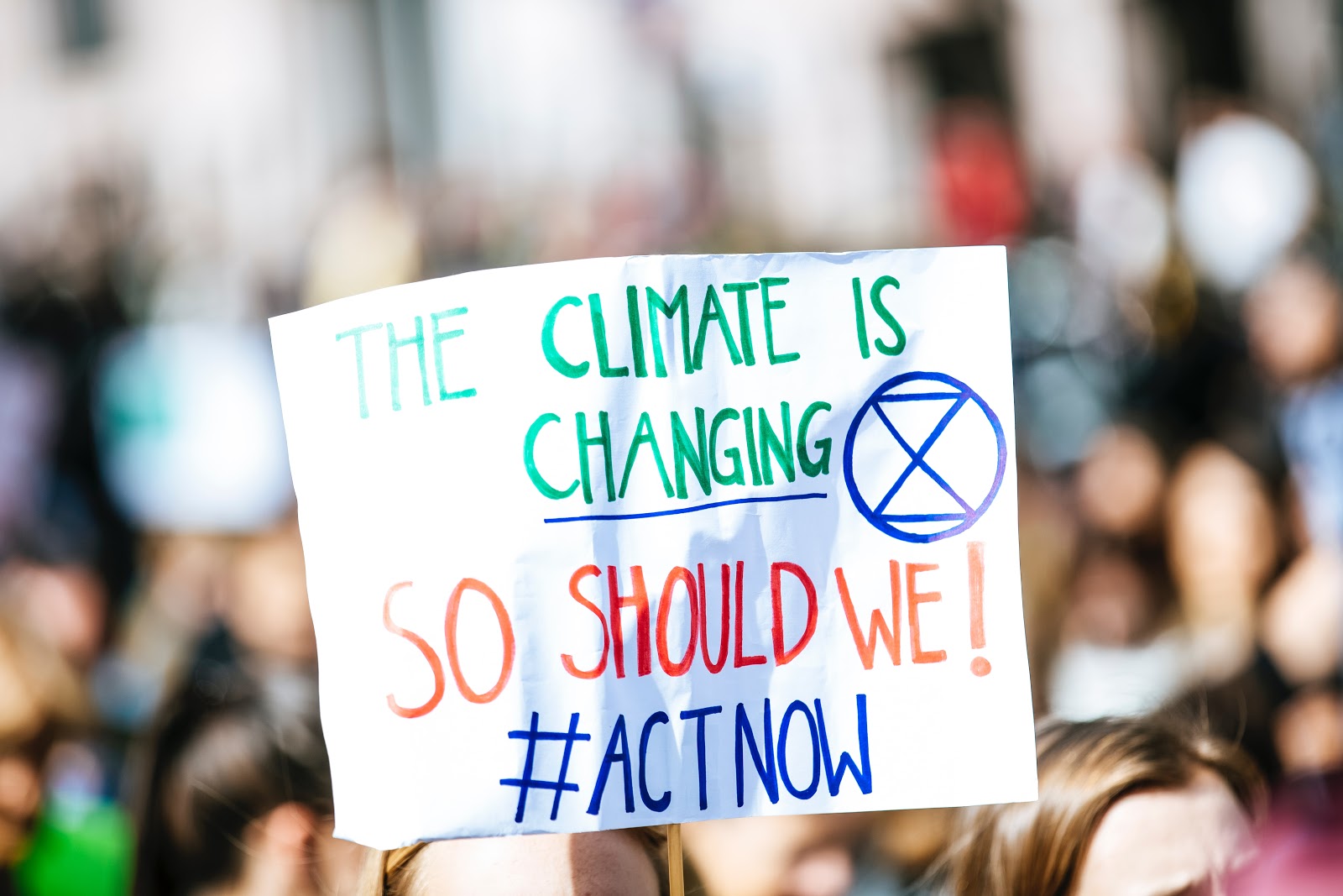 Protest sign with XR logo reading The climate is changing, so should we!#Act now 