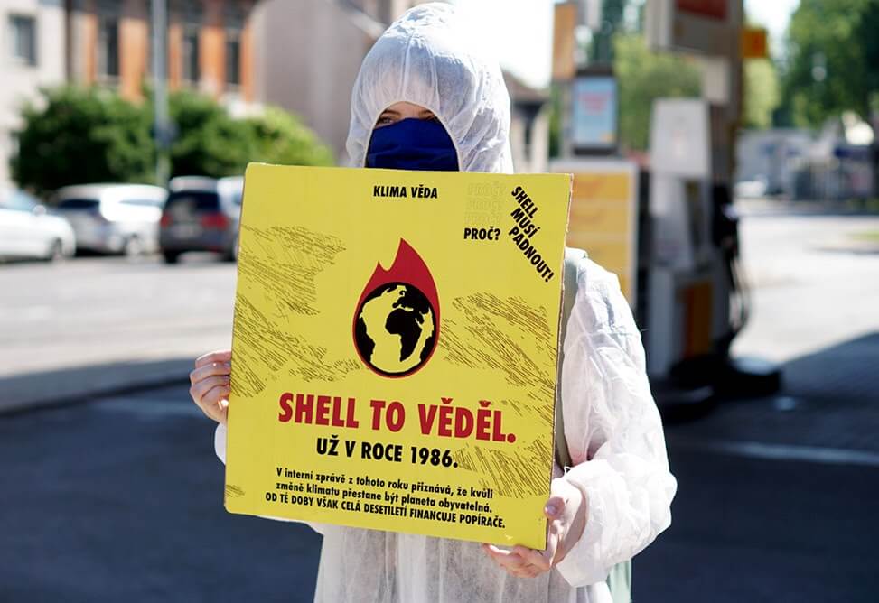 rebelde segurando sinal dizendo "Shell já sabia em1986"