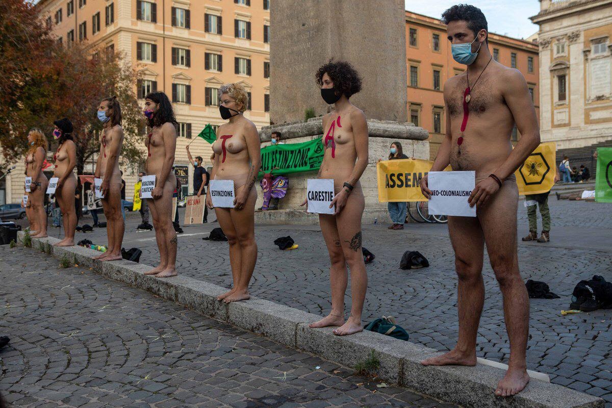 Italian rebels standing naked with signs in front of private parts.