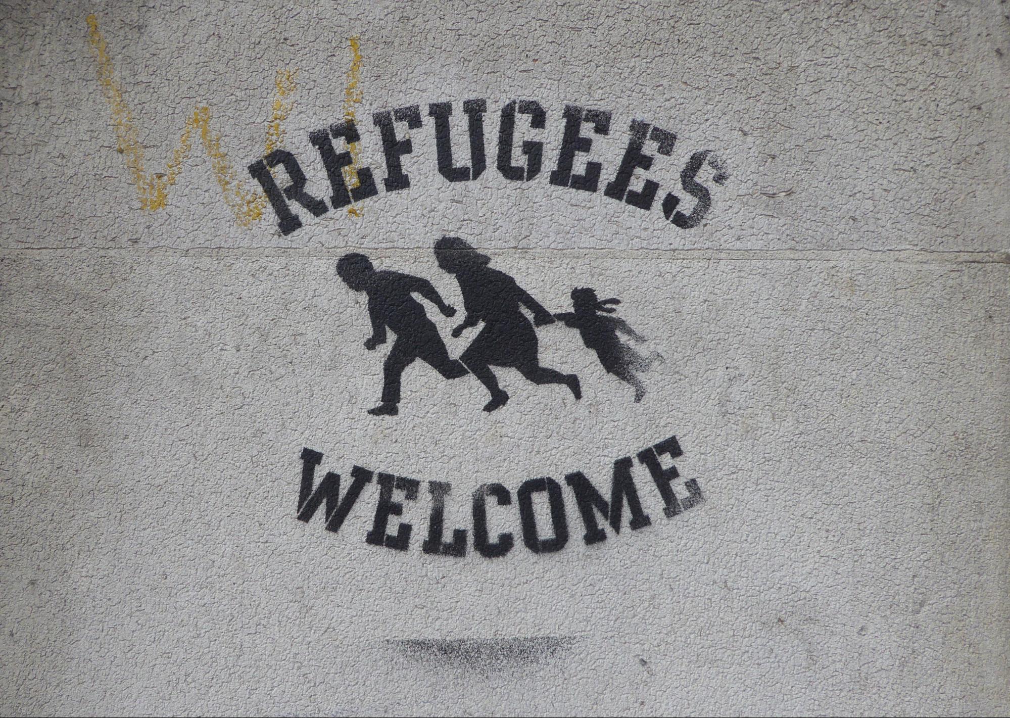 Sign on wall saying "Refugees welcome"