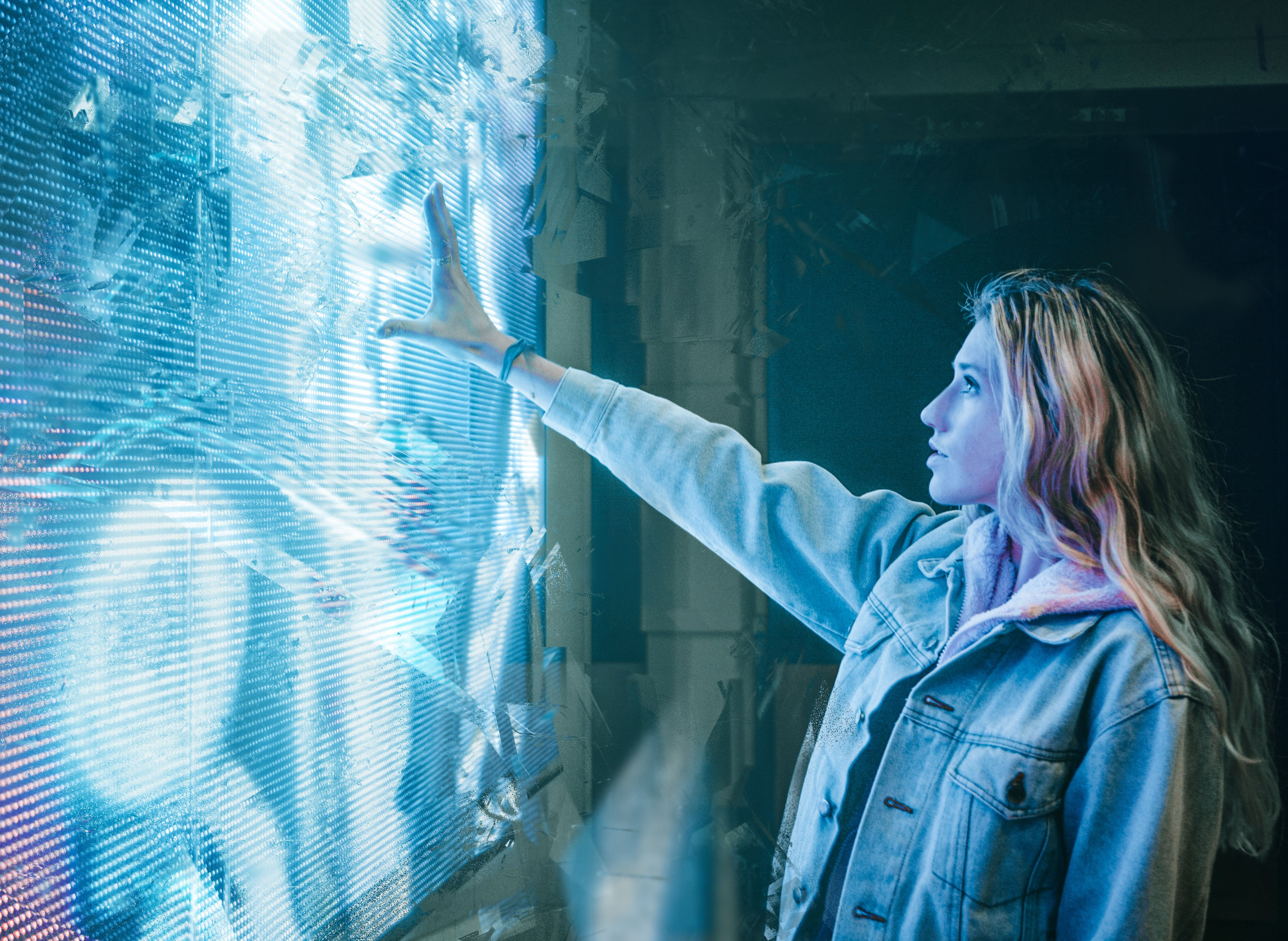 woman placing hand on futuristic-looking wall-sized monitor
