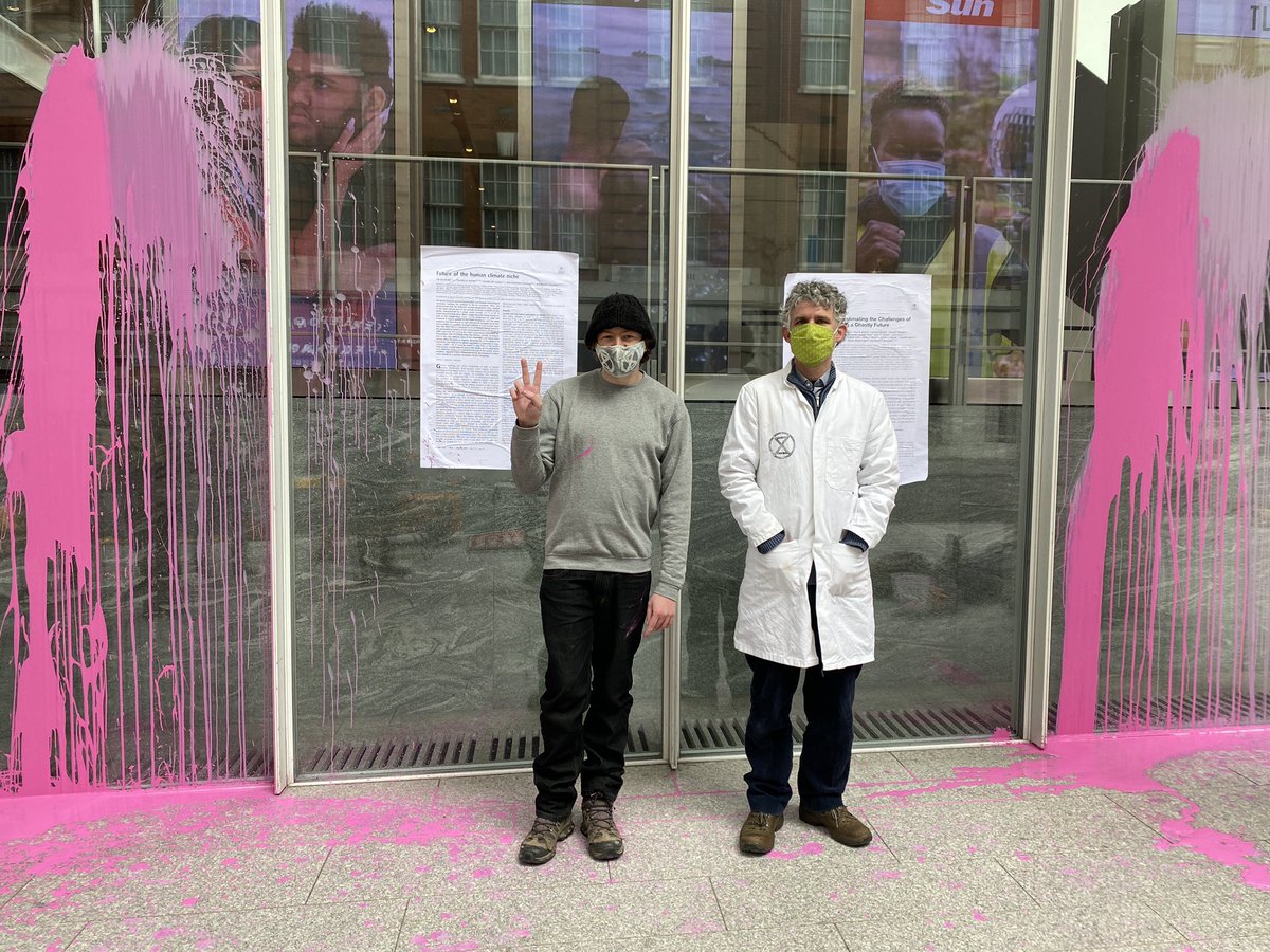 2 scientists throw paint and stick scientific papers to the UK HQ of Murdoch’s media empire