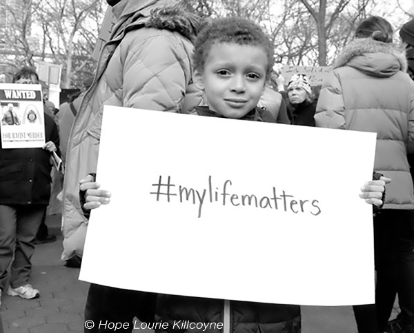 Young boy holds a sign saying #mylifematters