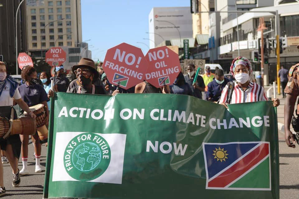 Abantu abaneempawu abathi "No fracking!" and "Action on climate changenow"